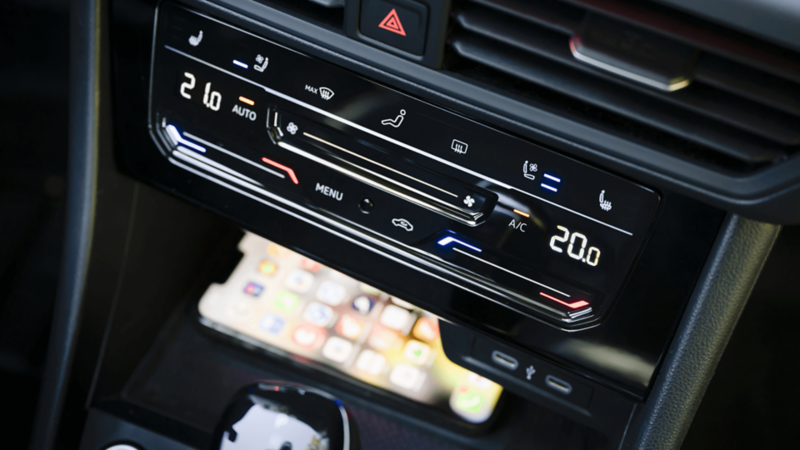 Close-up of the 2025 VW Jetta GLI's center console, highlighting the wireless device charging area beneath the climate controls.