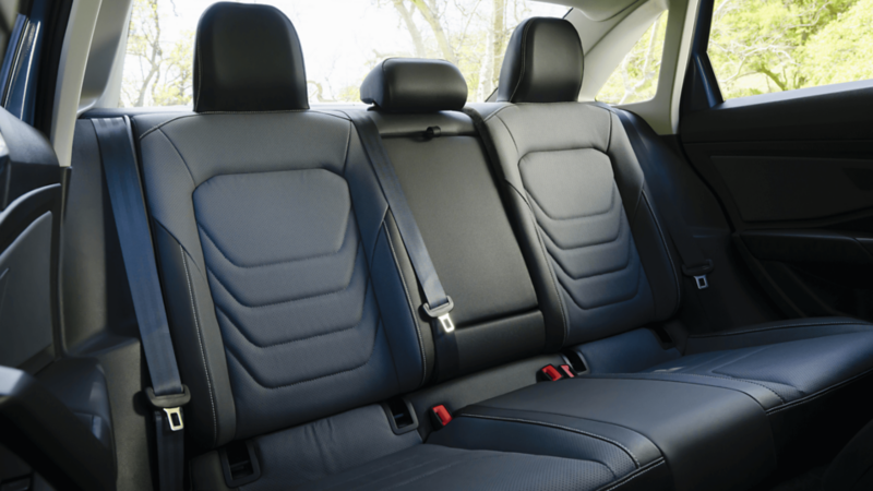 Rear interior of the 2026 Jetta featuring leather seats with visible stitching and ample legroom.
