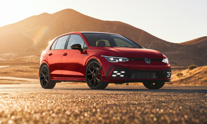 Golf GTI shown in Kings Red Metallic parked by a mountain road.