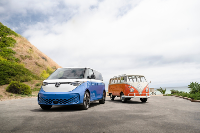 ID.Buzz van parked next to a vintage Volkswagen bus in an oceanside lot