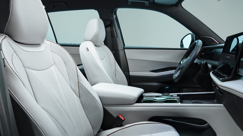 Interior view of an Atlas showing the front seats and dash with a studio setting visible through the windshield. 