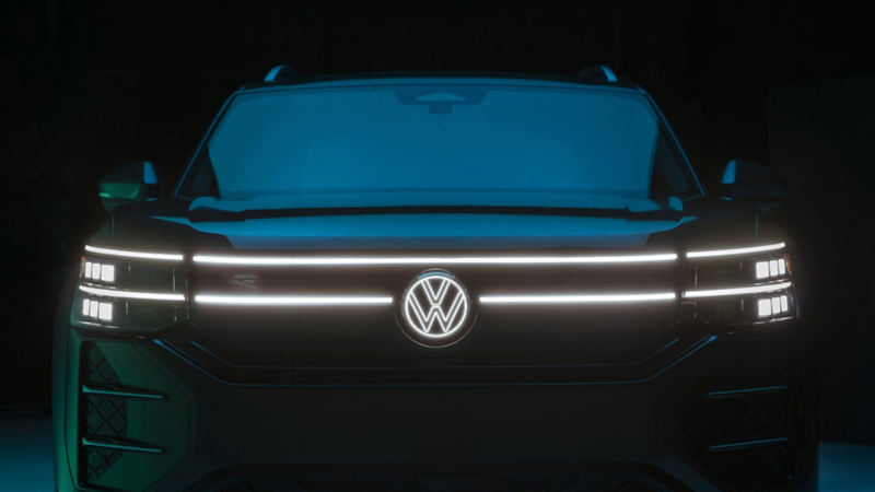 Close up view showing the available illuminated LED headlights and grille accents on an Atlas shown in Sacramento Green Metallic. 