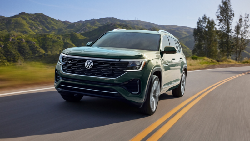 Front view of an Atlas in Avocado Green Metallic driving on a mountain road.
