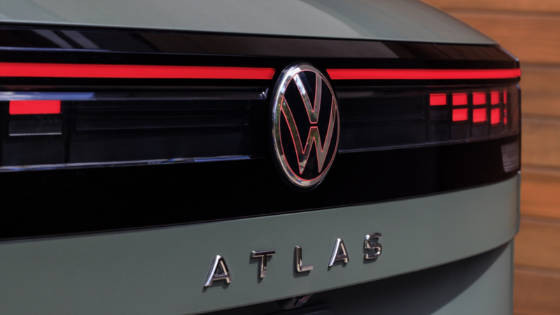 Close up view of the LED taillights and rear badging on an Atlas Cross Sport shown in Dark Sage Metallic.