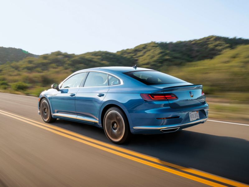 2023 VW Arteon in Kingfisher Blue Metallic, shown from rear three-quarter view.