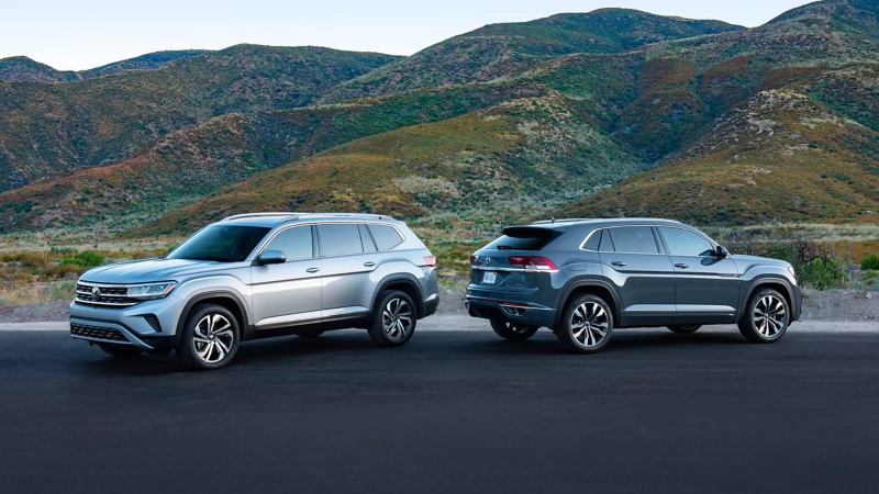 Silver mist metallic Atlas and platinum gray metallic Atlas Cross Sport are parked among mossy mountainous horizon. 