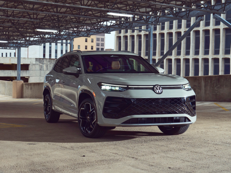 Front view of a Tiguan shown in Sandstone parked in a modern industrial parking garage.