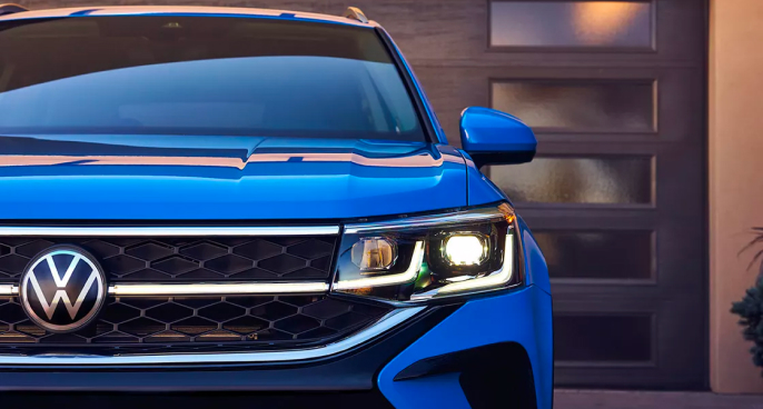 a front view of the 2024 Atlas in Metallic Blue parked in front of a modern home.