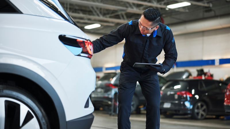 Un técnico realiza una inspección multipunto en un concesionario Volkswagen.