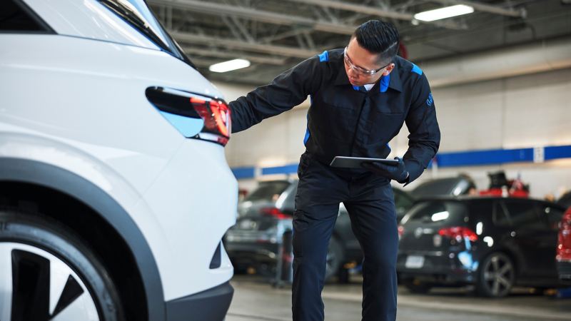 A technician performs a multi-point inspection at a Volkswagen dealership.