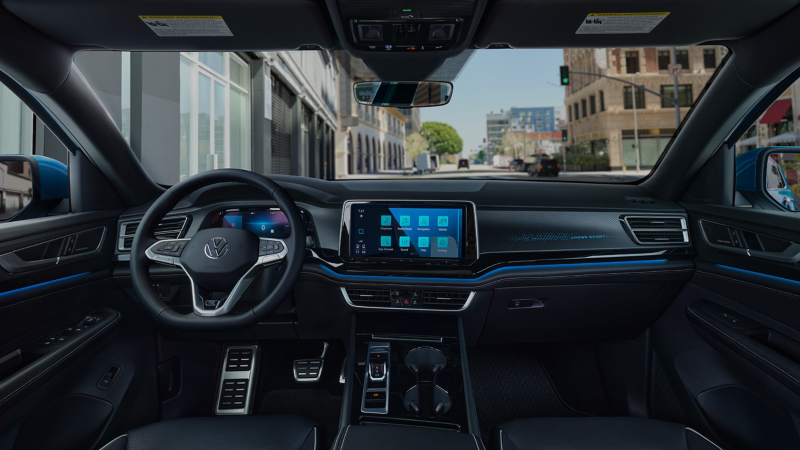 El interior de un Volkswagen Atlas Cross deportivo con una ciudad vista a través del parabrisas.