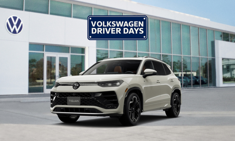 Front view of a Tiguan shown in Sandstone parked in front of a VW dealership with a Volkswagen Driver Days graphic floating above the vehicle.