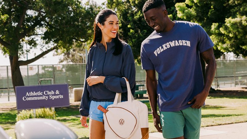 A couple walking toward a Volkswagen vehicle wearing athletic clothing.