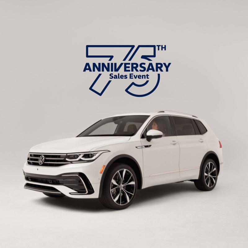 Front view of a Tiguan shown in Opal White parked on a white background with sales event logo superimposed on image.