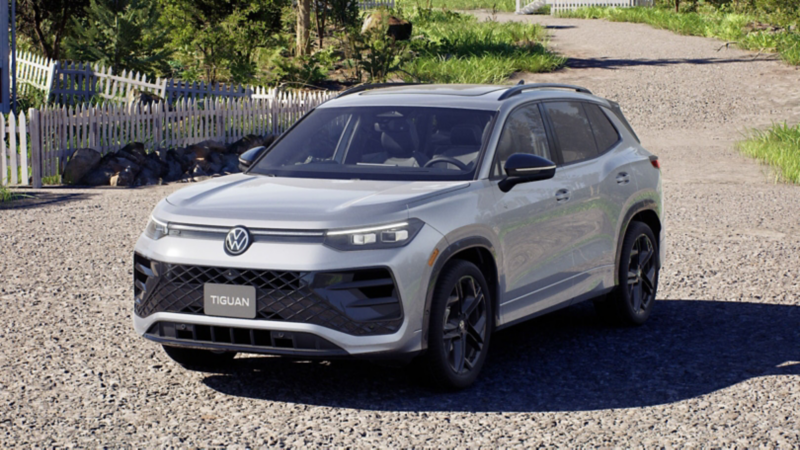 Front view of an Tiguan in Platinum Gray Metallic parked in front of house with the front gate and driveway in the background.