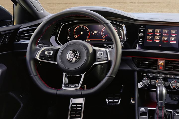 The VW Golf GTI digital cockpit, media touch screen, and famous flat-bottom steering wheel with honeycomb detail.