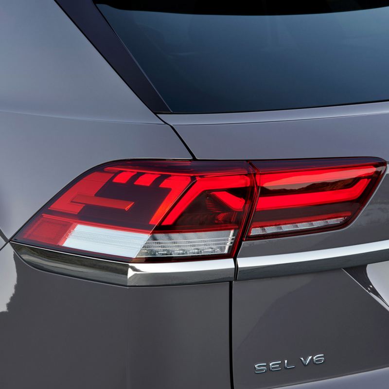 Toma angular y recortada de un Atlas V6 SEL de Volkswagen color Platinum Gray Metallic que muestra las luces LED traseras del lado del conductor.