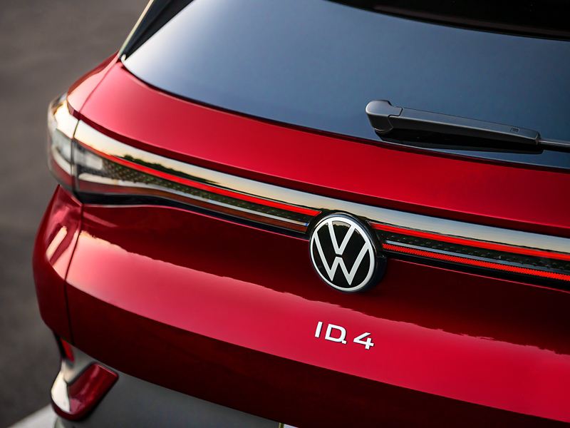 Primer plano de la parte trasera de un ID.4 de color Aurora Red Metallic con énfasis en las luces traseras, el emblema de VW y el logotipo del ID.4.