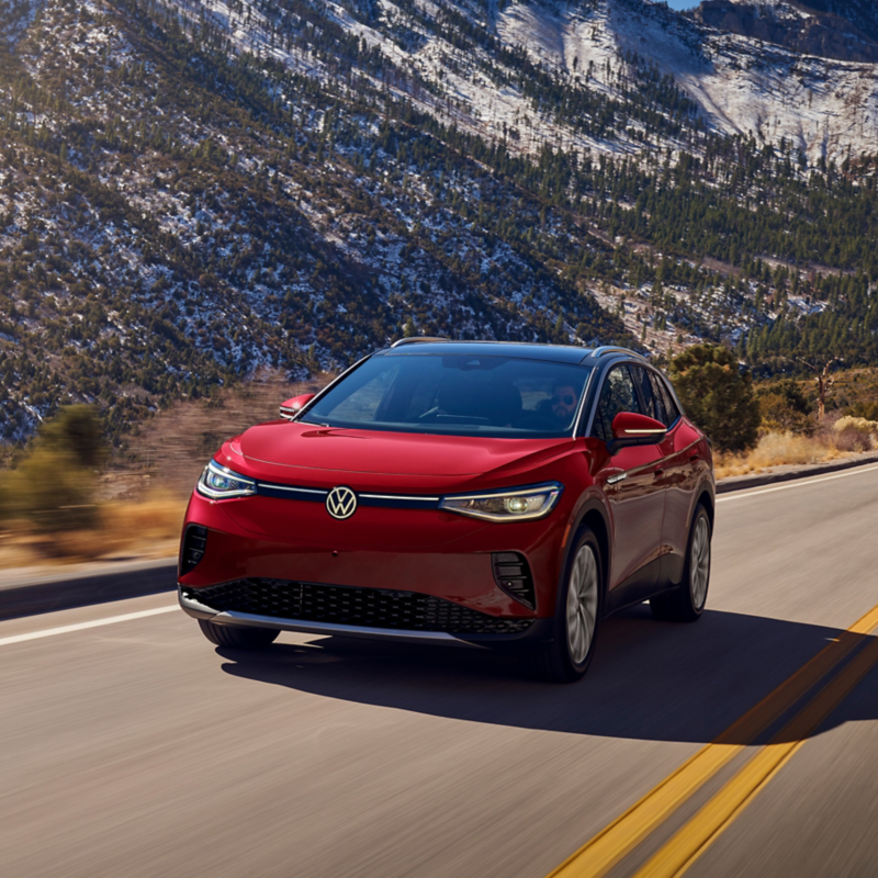 A shot of an ID.4 Pro S Plus in Aurora Red Metallic driving up a two-lane mountain road.