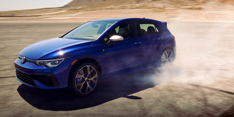 Golf R shown in Lapiz Blue Metallic, cornering with tires smoking.