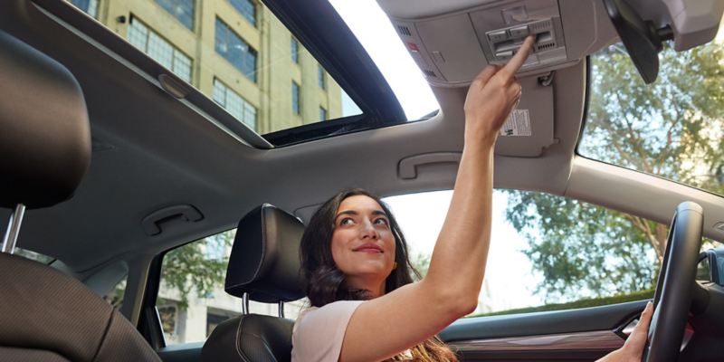 Available panoramic sunroof in use by a person seated in the driver seat.