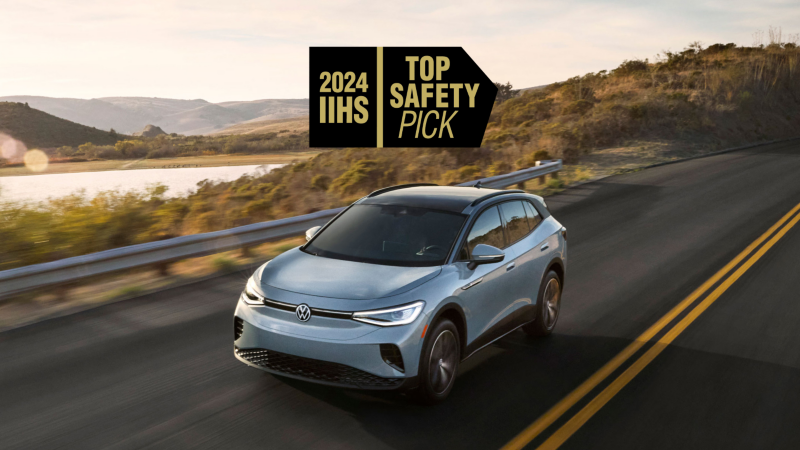 Vista frontal de un ID.4 en azul ártico metálico manejando con montañas y un lago en el fondo con un gráfico IIHS TOP SAFETY PICK 2024 superpuesto en la imagen.