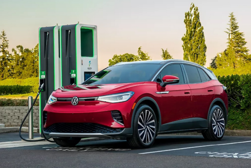 An ID.4 shown in Aurora Red Metallic parked at a charging station.