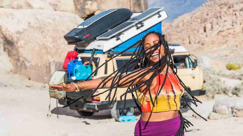 Woman dances in front of Volkswagen Vanagon Westfalia