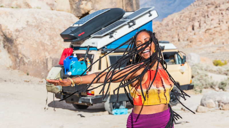 Woman dances in front of Volkswagen Vanagon Westfalia