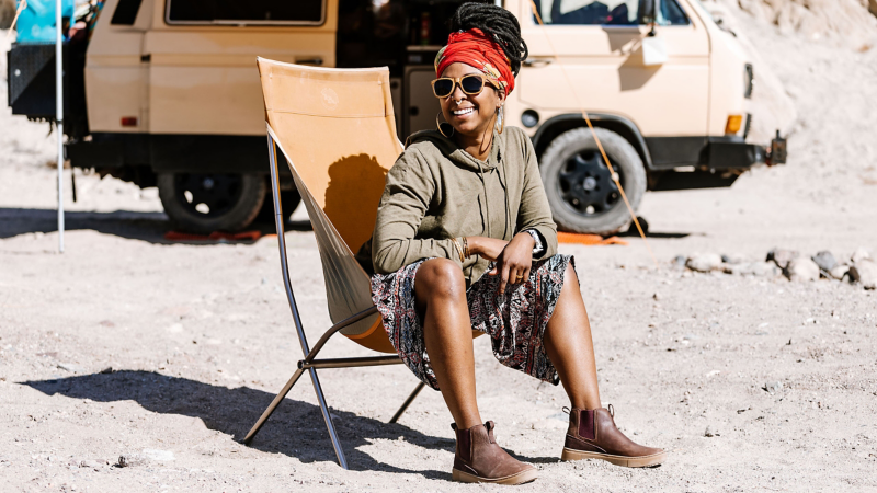 Woman sits in front of a Volkswagen Vanagon Westfalia