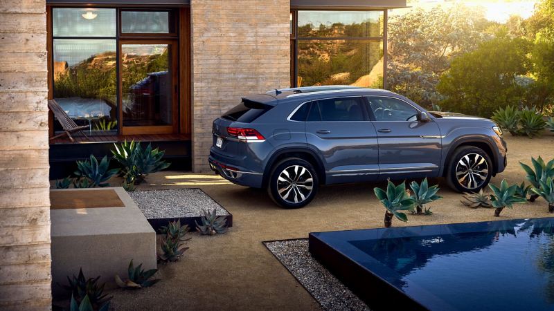 This is an exterior shot of the 2020 Atlas SEL V6, side profile, outside a luxury home.