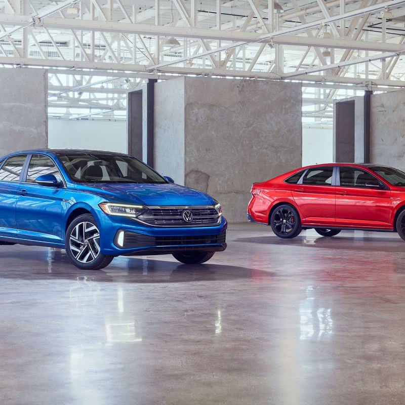 Product shot of the 2022 Volkswagen Jetta and 2022 Volkswagen 2022 Jetta GLI side by side in a studio.