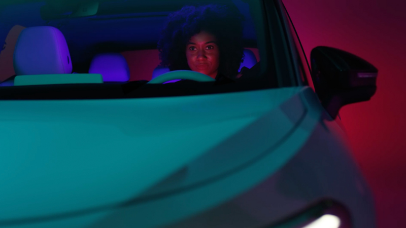 Imagen de una mujer conduciendo un auto en la carretera.