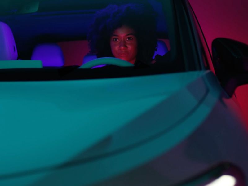 Image of a woman driving a car down the road.
