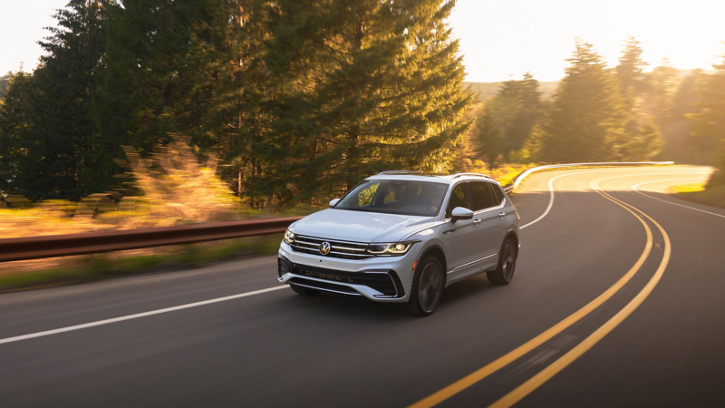 2023 VW Tiguan, shown in Opal White, driving on a winding road.