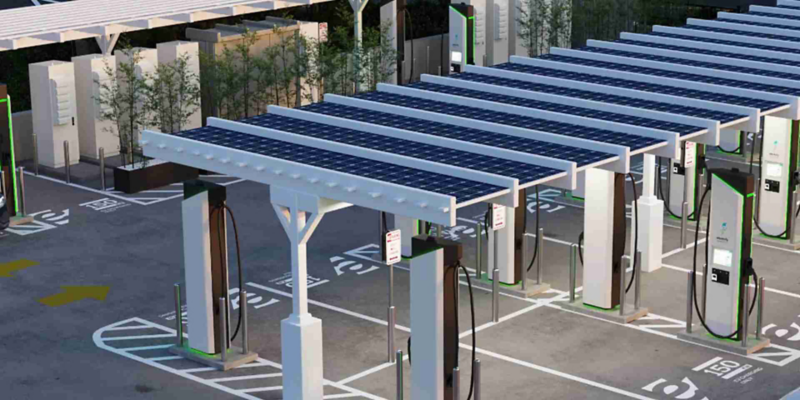 Photo illustration: aerial view of an Electrify America charging station, showing solar canopies.