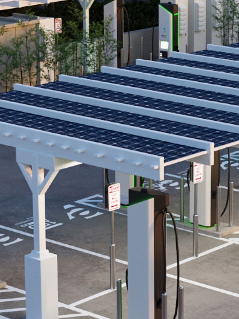 Photo illustration: aerial view of an Electrify America charging station, showing solar canopies.