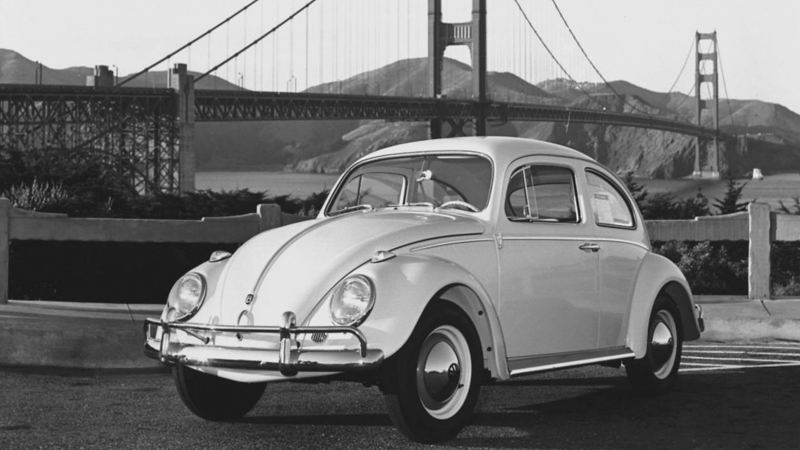 Un Volkswagen Beetle vintage frente al puente Golden Gate.
