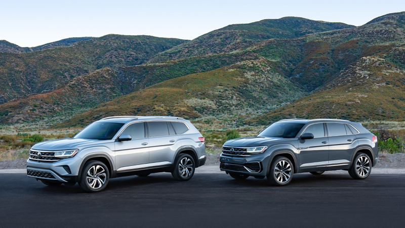 El Atlas 2020.5 y el Atlas Cross Sport 2020 de Volkswagen se encuentran uno al lado del otro frente a colinas verdes.