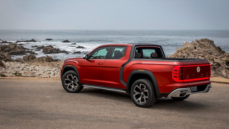 El concepto Volkswagen Tanoak 2018 está estacionado en un mirador frente al océano, y se muestra el vehículo visto de frente y de lado. 