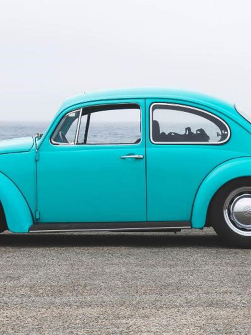 Vintage Volkswagen Beetle parked in front of the ocean