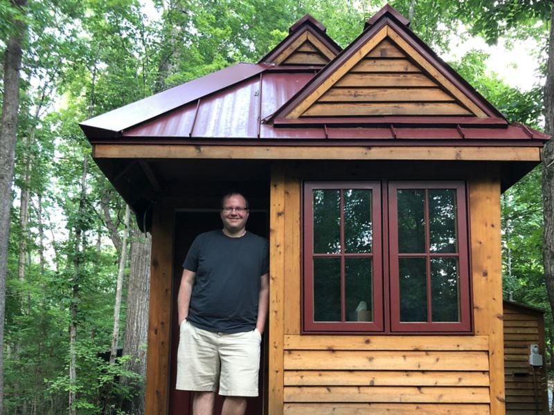 Ryan Mitchell, tiny-home expert, stands at the entrance of his house.