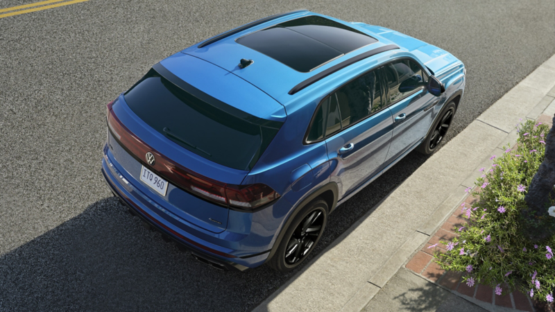 Bird’s-eye rear view of the Atlas Cross Sport in Kingfisher Blue Metallic parked on the side of a street.