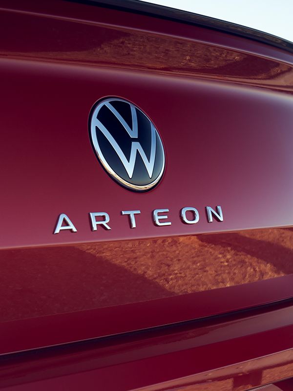 Rear view of an Arteon in Kings Red Metallic featuring the rear badging with Arteon name centered beneath VW emblem.