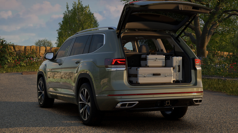 Rear view of a parked Atlas shown in Avocado Green Metallic with the rear liftgate open showing properly secured luggage in the cargo area.