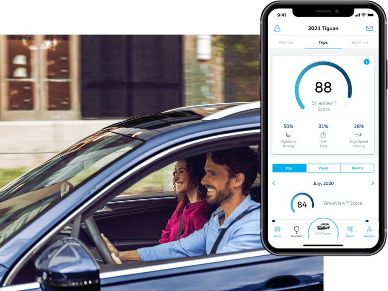 A man is driving his VW, the in-app, VW Car-Net® Remote Access DriveView is displayed on a superimposed mobile phone.