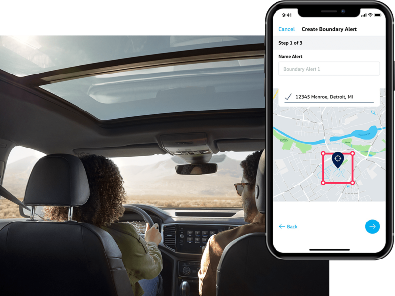 A man and woman sit in their VW with the in-app, VW Car-Net® Remote Access boundary parameter displayed on a superimposed mobile phone.