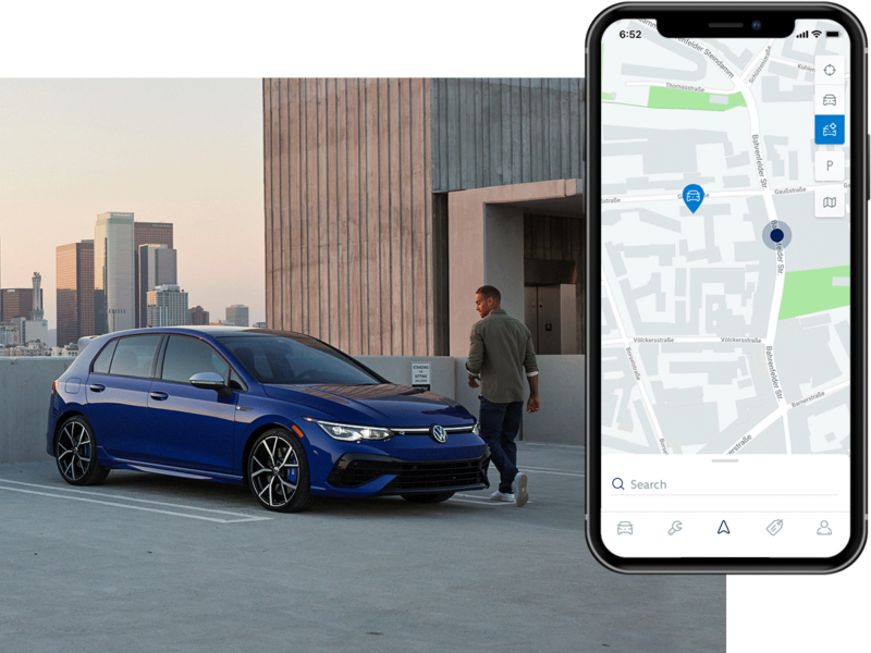 Person walking toward a Golf R shown in Lapiz Blue Metallic parked on a rooftop parking lot. The MyVW app is displayed on a superimposed mobile phone.