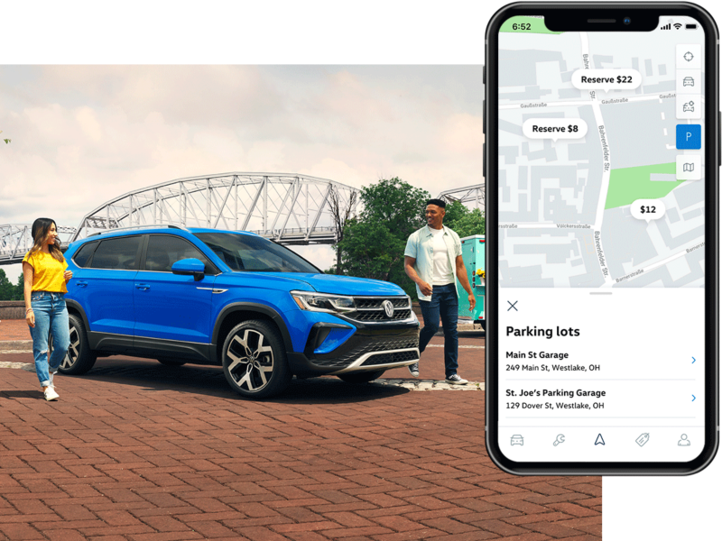 A Taos in Cornflower Blue parked in front of a lake as seen from behind.The MyVW app is displayed on a superimposed mobile phone.