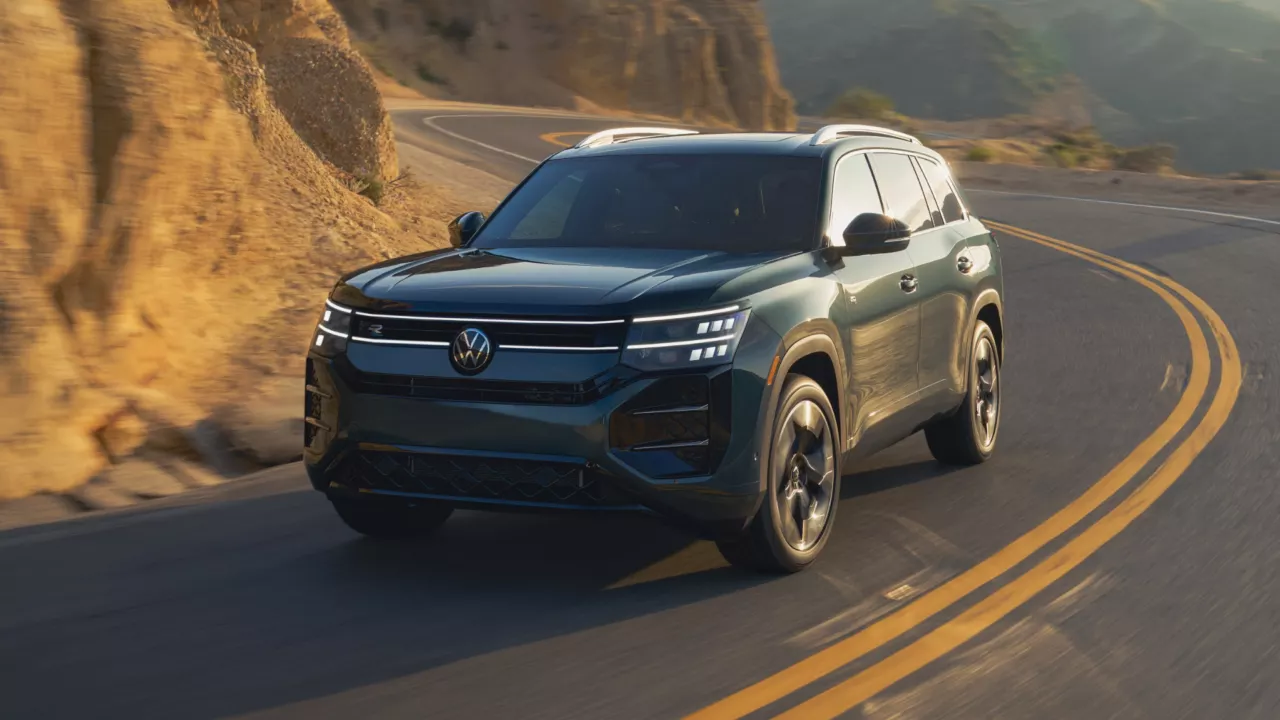 Front view of an Atlas shown in Sacramento Green Metallic driving on a mountain road.